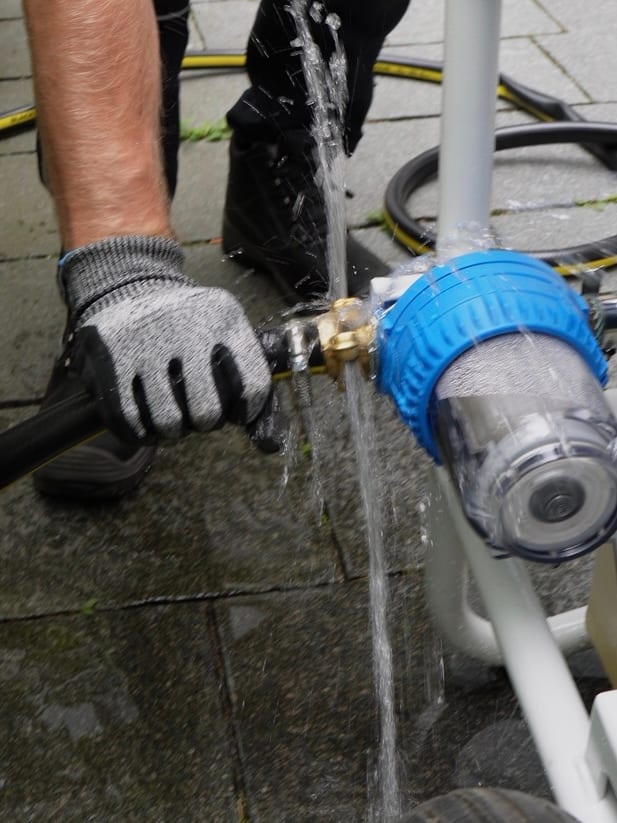 Nahaufnahme: Wasserfilter am Gerät wird angeschlossen